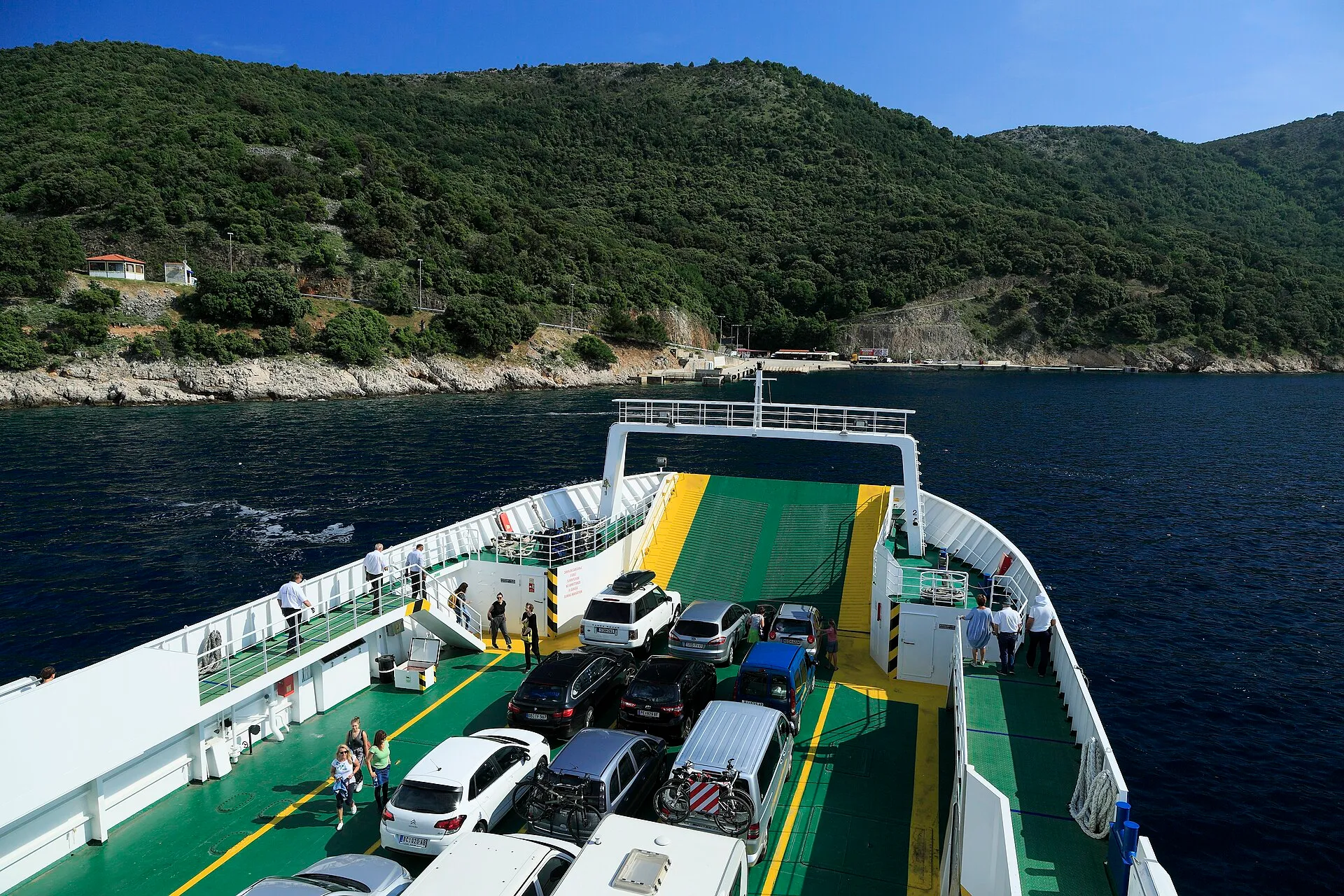 Cars on the deck during the crossing, with the wooded coast of Cres ahead